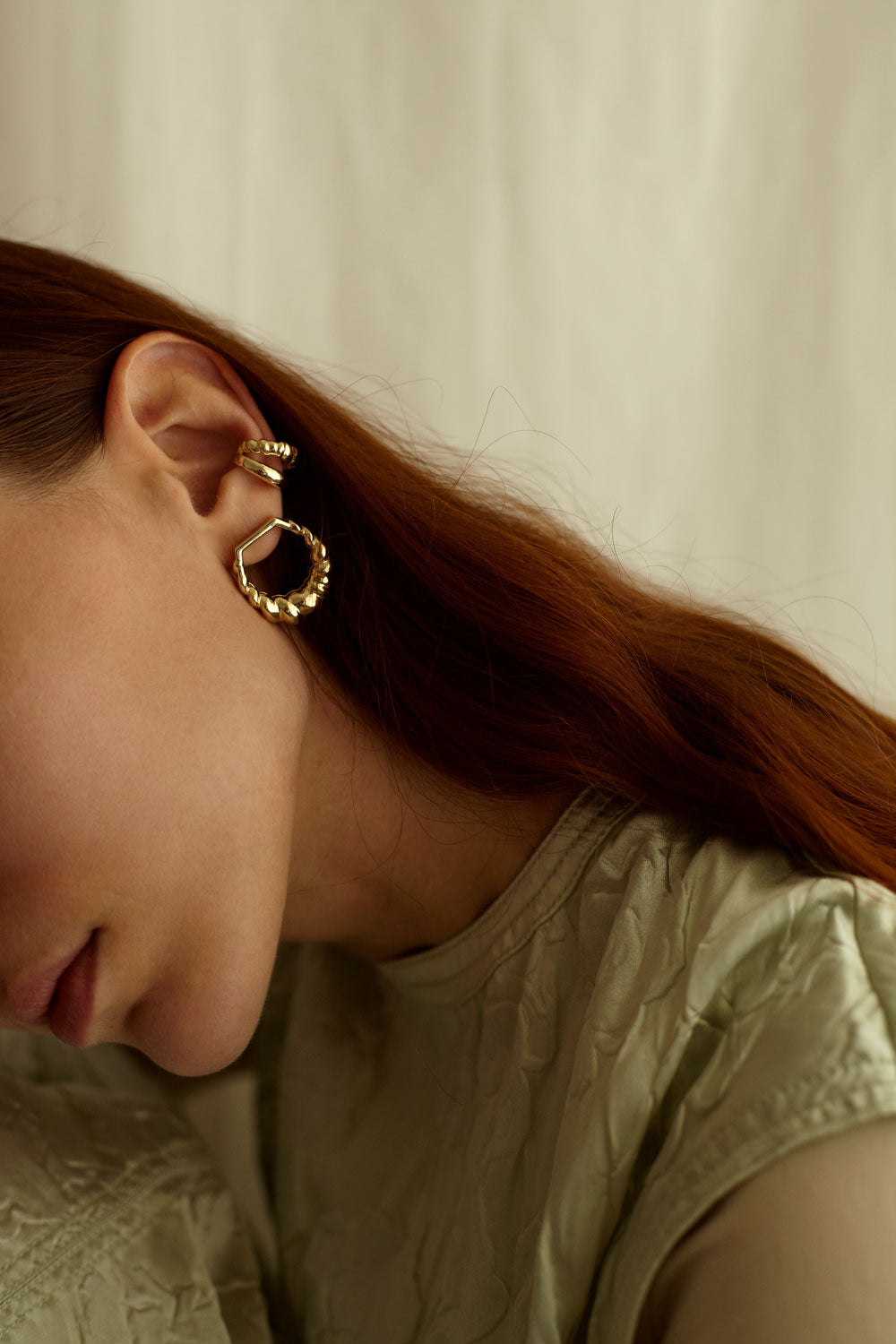 orecchino in oro della collezione echoes indossato in combinazione con altri orecchini oro