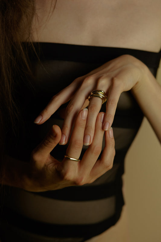 combinazione di anelli indossati sulle mani in oro giallo by piqué